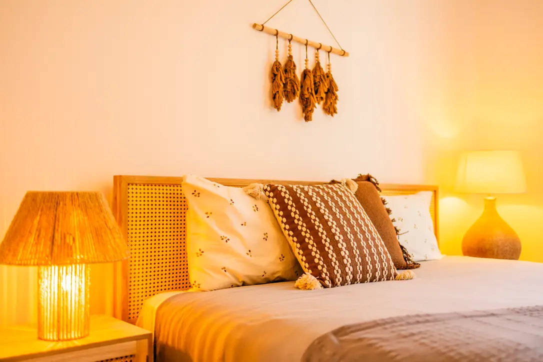 Accessible ground-floor bedroom with patterned cushions and macramé wall art, Villa Crossdeira