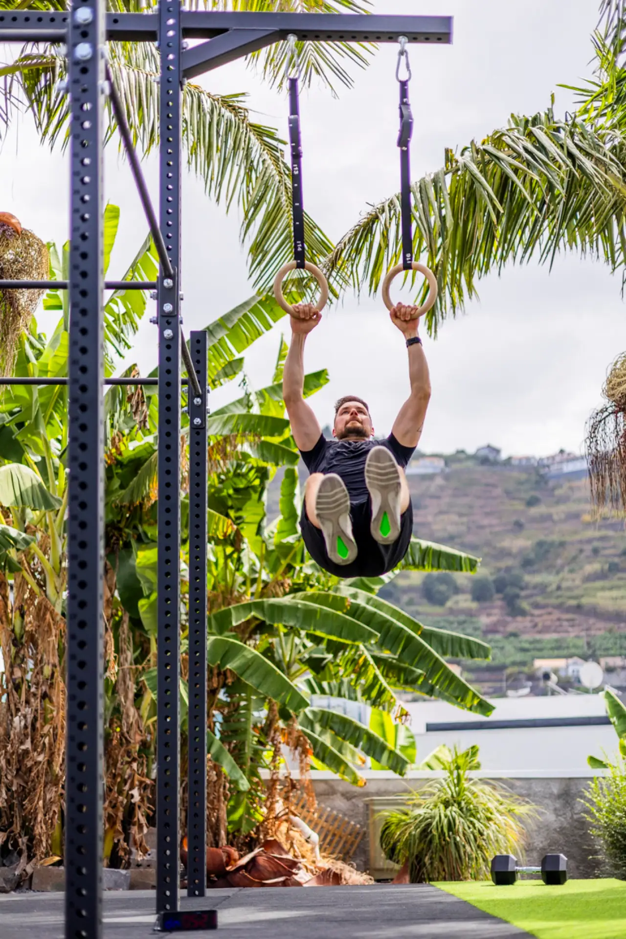 Athlete training on gymnastic rings in the outdoor gym with valley view, Villa Crossdeira Madeira