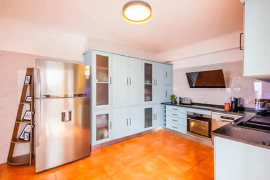 Fully equipped kitchen with light-blue cabinets and terracotta floor, Villa Crossdeira