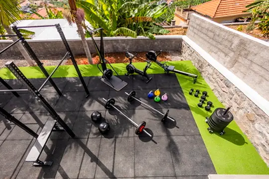 Outdoor gym from above with barbells and dumbbells on green turf, Villa Crossdeira