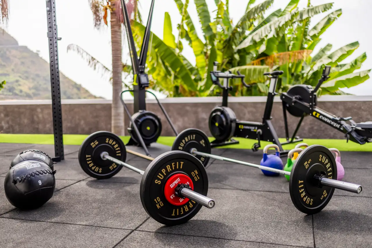 Outdoor gym with Suprfit barbells, bumper plates and kettlebells on artificial turf, Villa Crossdeira