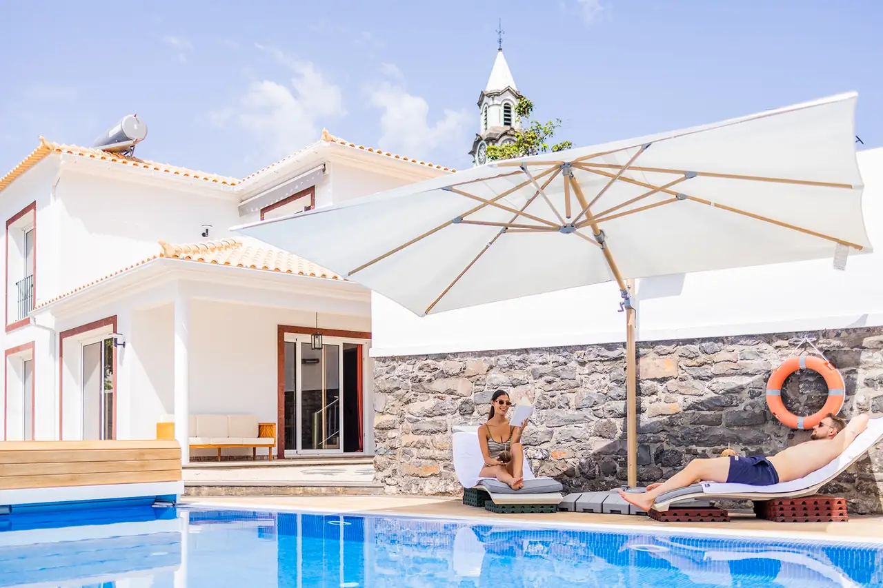 Private swimming pool with sun loungers and the church tower of Arco da Calheta behind, Villa Crossdeira