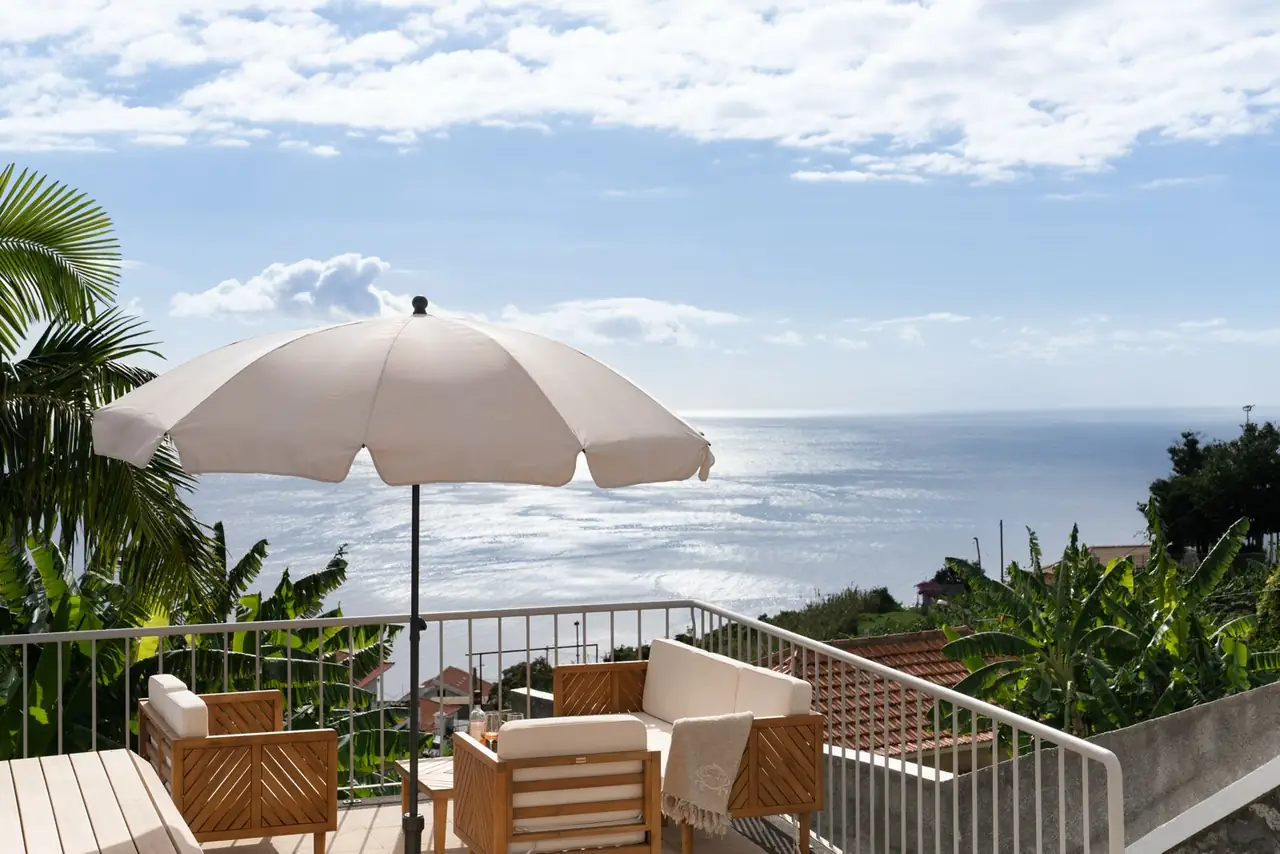 Sea-view terrace with parasol and lounge seating above the Atlantic, Villa Crossdeira, Arco da Calheta